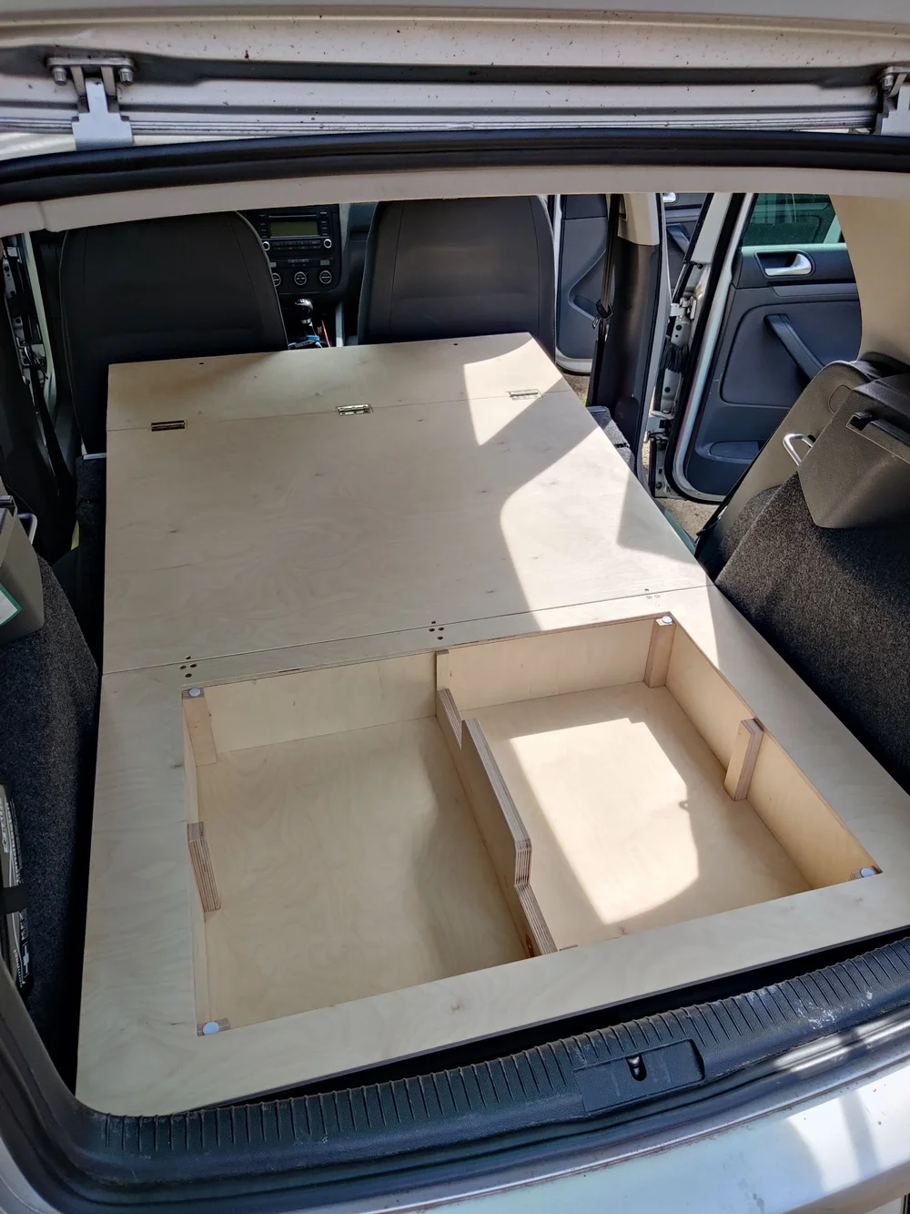 Geöffnetes Staufach der Rost Box mit zwei Birkenholz-Fächern im VW Golf